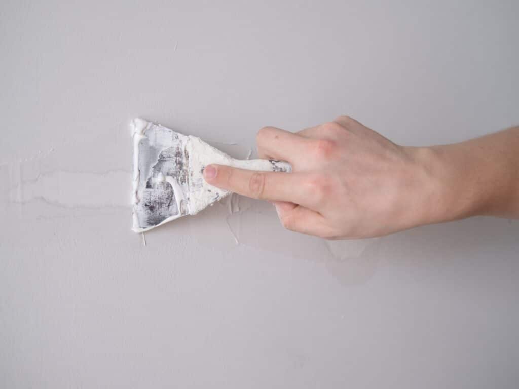 aplicando masilla en grieta de pared