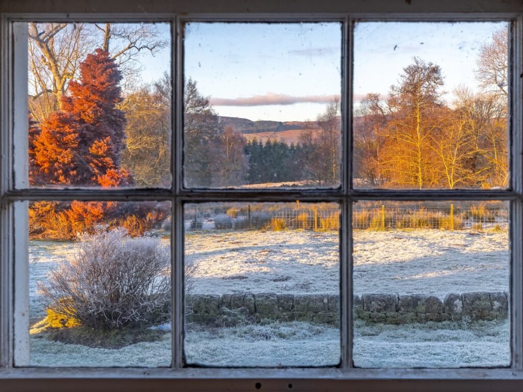 Ventana de madera antigua con escarcha al otro lado del cristal